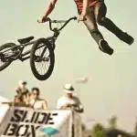 Ciclista de BMX faz salto com acrobacia durante evento esportivo