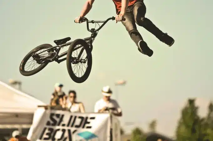 Ciclista de BMX faz salto com acrobacia durante evento esportivo
