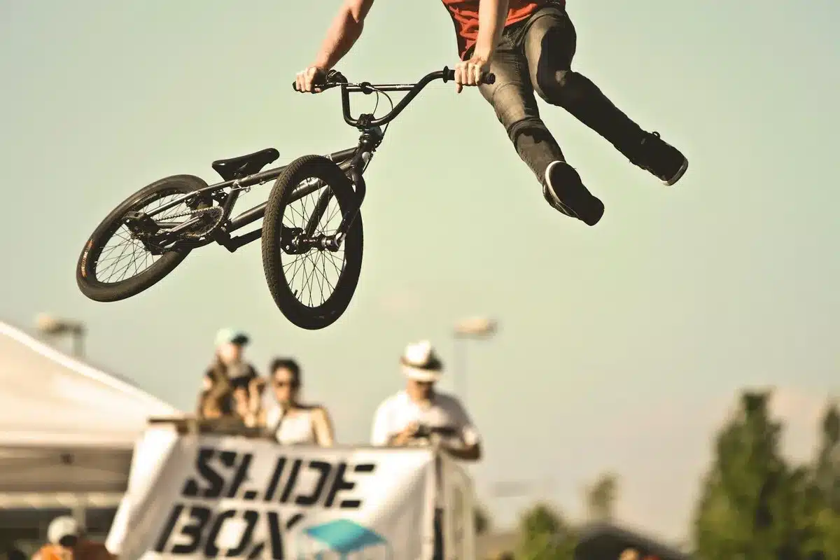 Ciclista de BMX faz salto com acrobacia durante evento esportivo