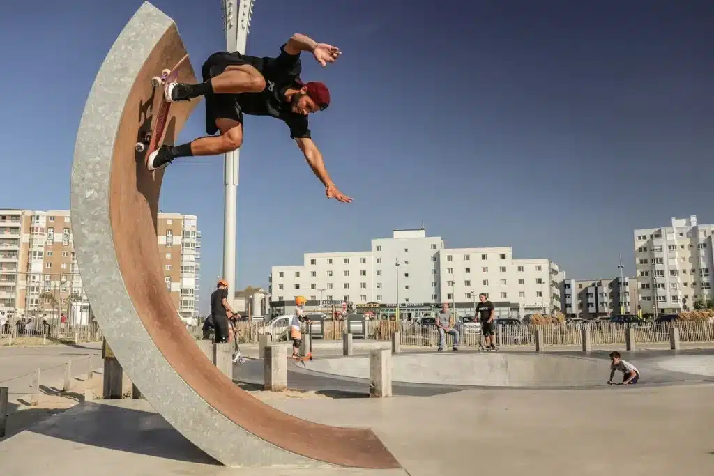 Skatista realizando manobra em rampa vertical em parque de skate urbano ao ar livre.