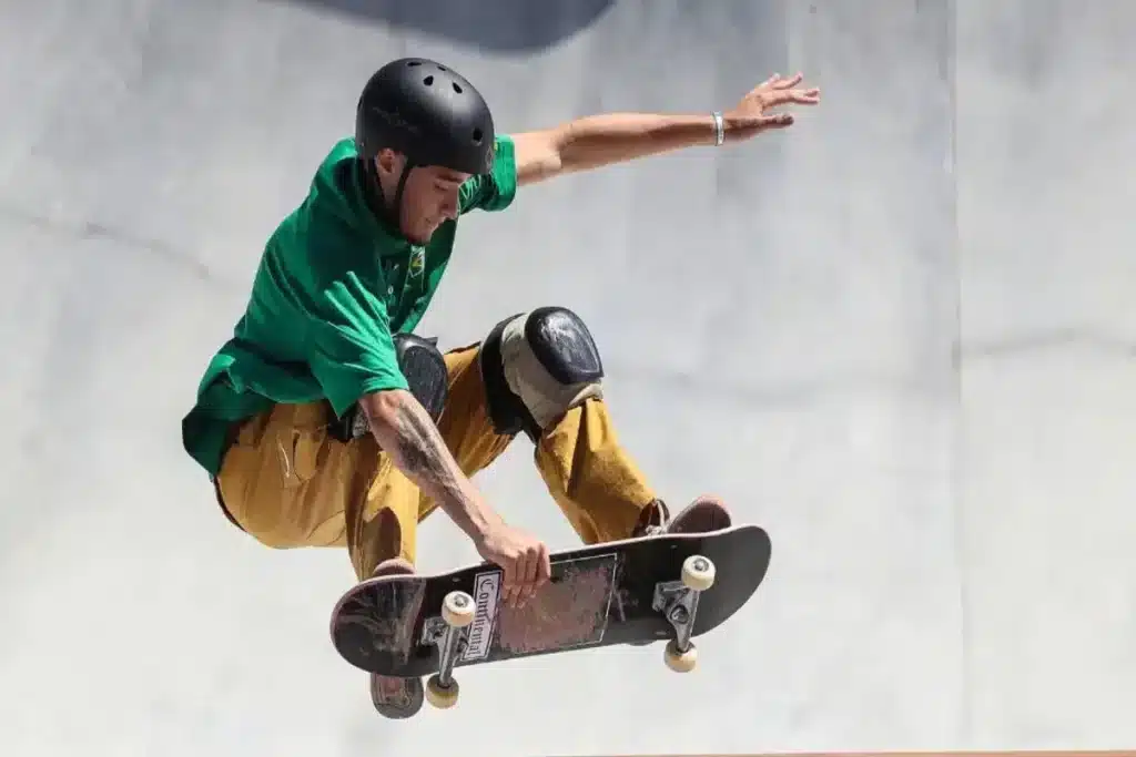 Skatista brasileiro realizando manobra aérea em pista de skate park.