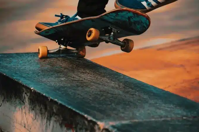 Skatista realizando manobra de grind em caixote de concreto no skate park.