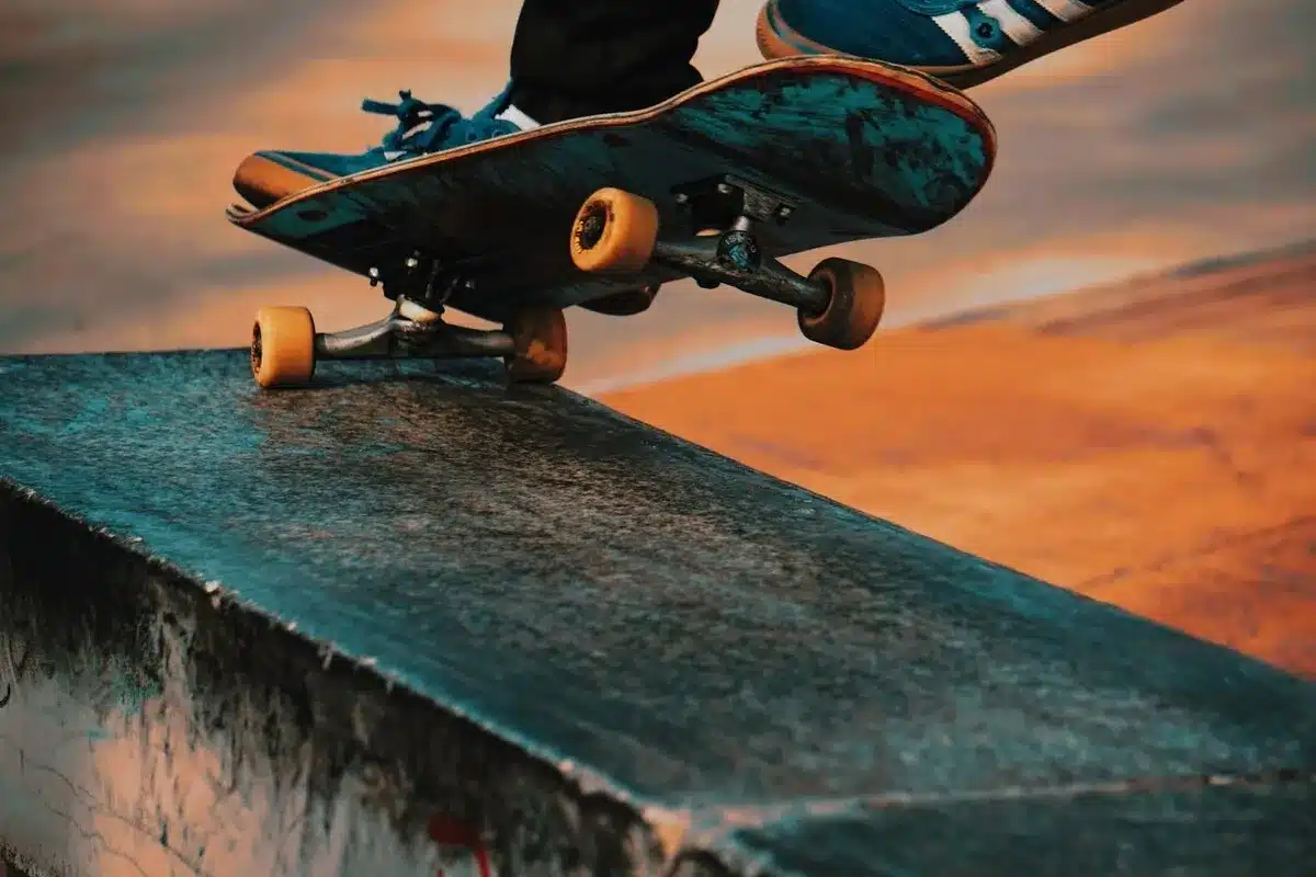 Skatista realizando manobra de grind em caixote de concreto no skate park.