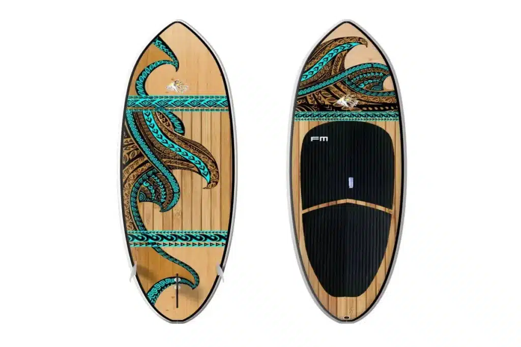 Prancha para SUP de madeira clara com padrões tribais em azul turquesa e marrom escuro na parte superior, e uma prancha para SUP idêntica com deck pad preto na parte inferior.