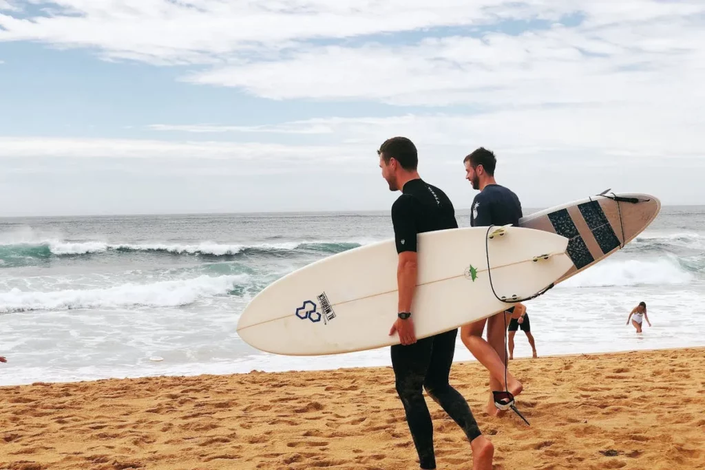 Duas pessoas na praia, cada uma com sua respectiva prancha de surf