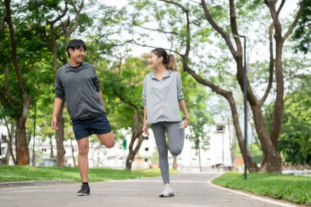 Duas pessoas alongando as pernas ao ar livre