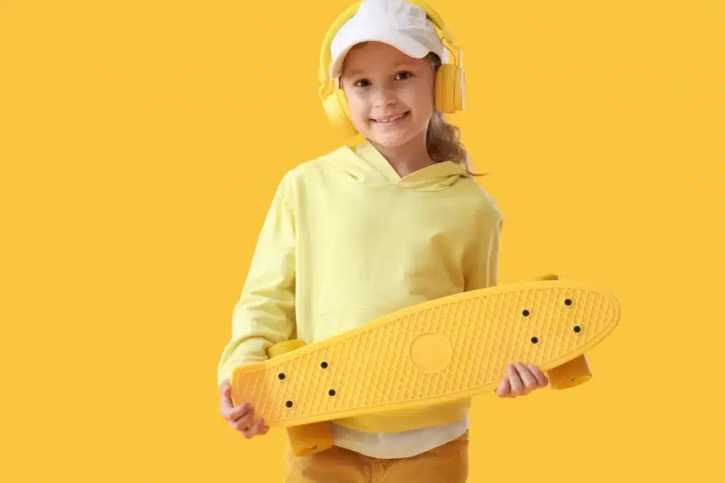 Menina segurando skate amarelo