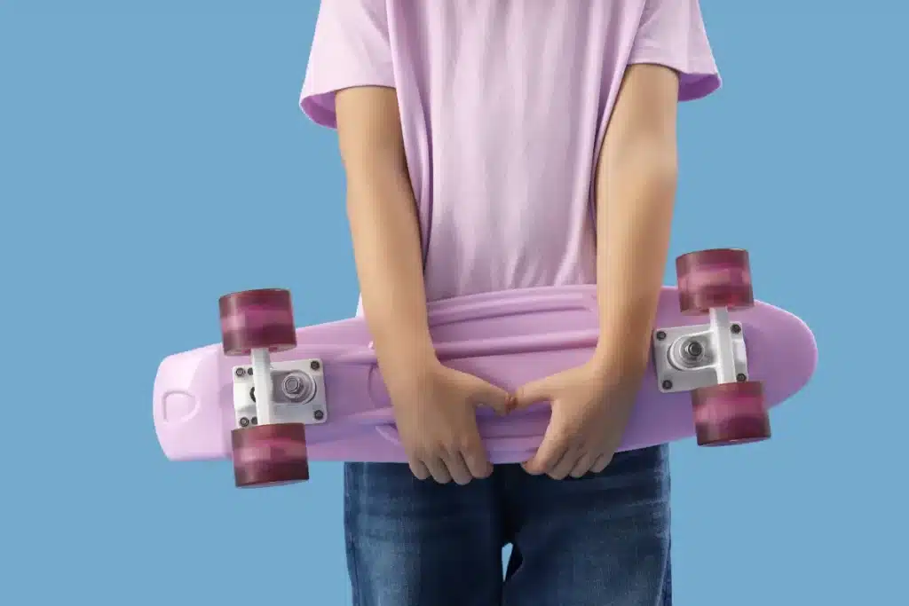 Menina segurando skate lilás