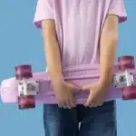 Menina segurando skate lilás