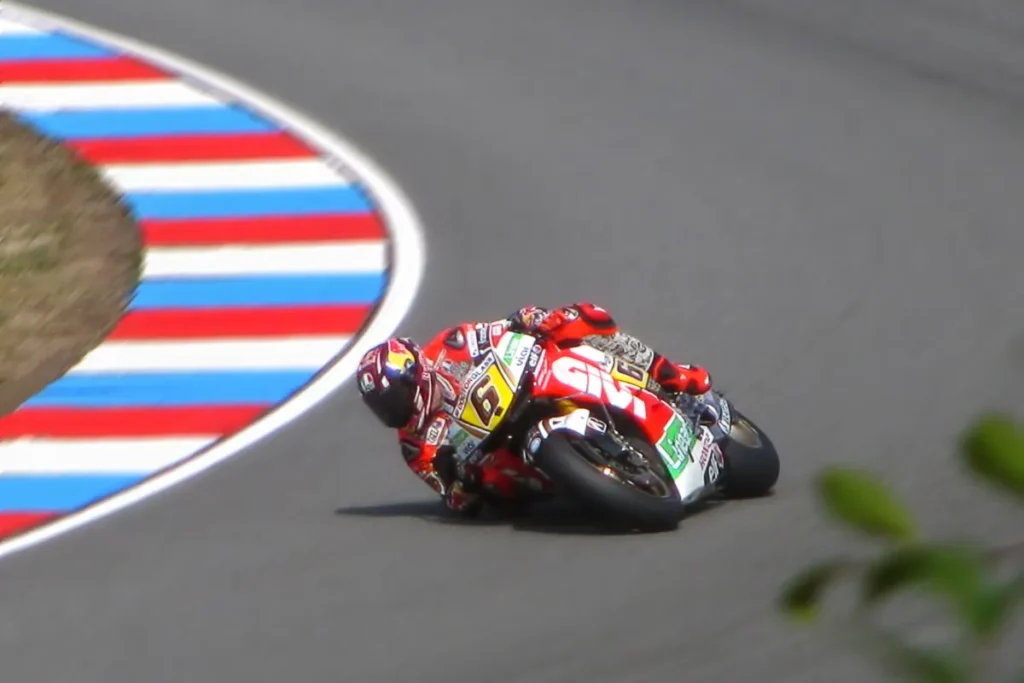 piloto de motocicleta esportiva fazendo curva fechada em pista de corrida